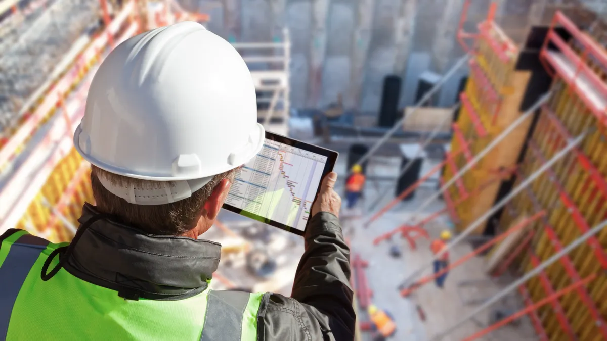 construction manager using tablet at smart construction site with digital project planning